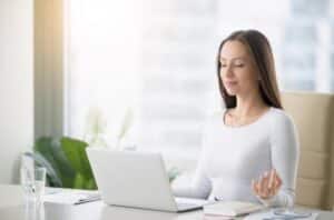 Une femme pratiquant la méditation, symbolisant comment celle-ci aide à réduire les erreurs du cerveau.